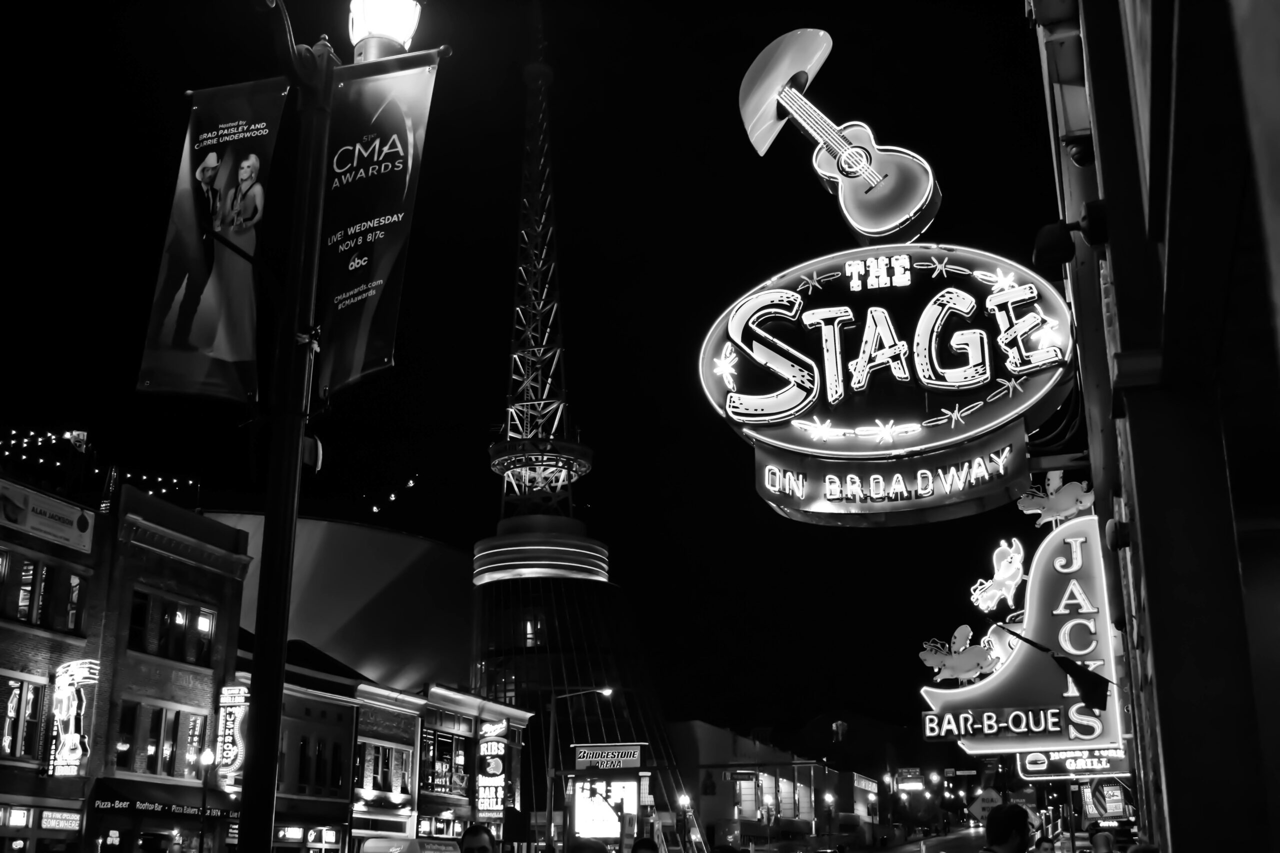 Black and white photo capturing the lively neon-lit signs of Broadway Street, Nashville at night.